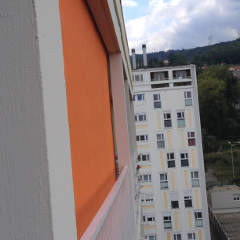 store en façade d'immeuble avec stores bannette orange enroulement vertical