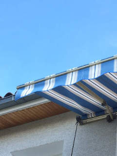 toile de stores rayées bleus sur balcon villa